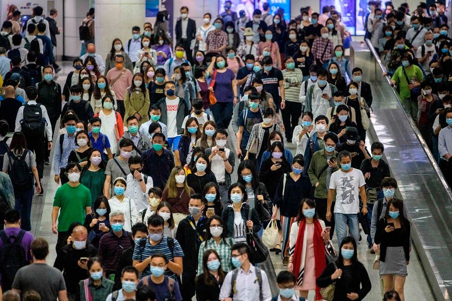 Commuters wearing face masks walk in an MTR underground metro station amid the Covid-19 coronavirus pandemic in Hong Kong on 25 November 2020. (Anthony Wallace/AFP)