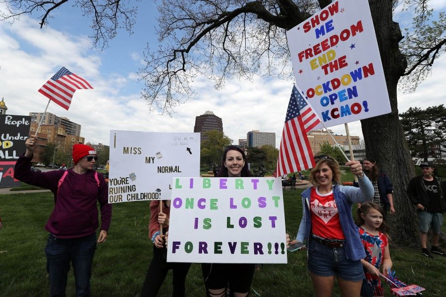 Protesters hold signs in Kansas City, Missouri, April 20. The protest was part of a growing national movement against stay-at-home orders designed to slow the spread of the coronavirus. (Jamie Squire/AFP)