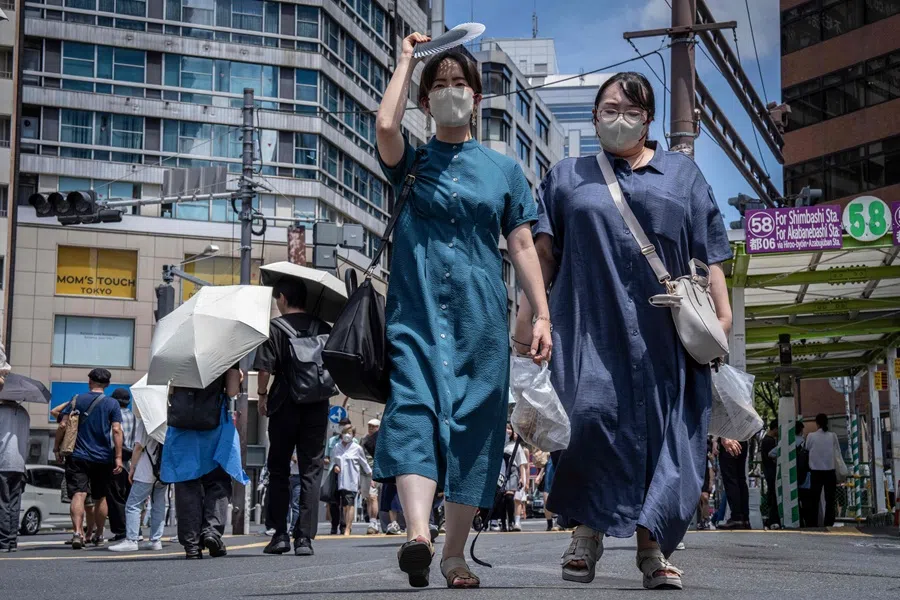 People walk along a street in Shibuya area of Tokyo on 14 August 2025. (Yuichi Yamazaki/AFP)