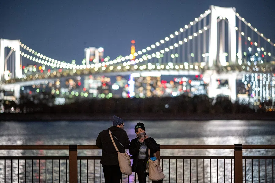 People visit Odaiba Marine Park as the Rainbow Bridge is seen in the background in Tokyo on 13 December 2023. (Philip Fong/AFP)