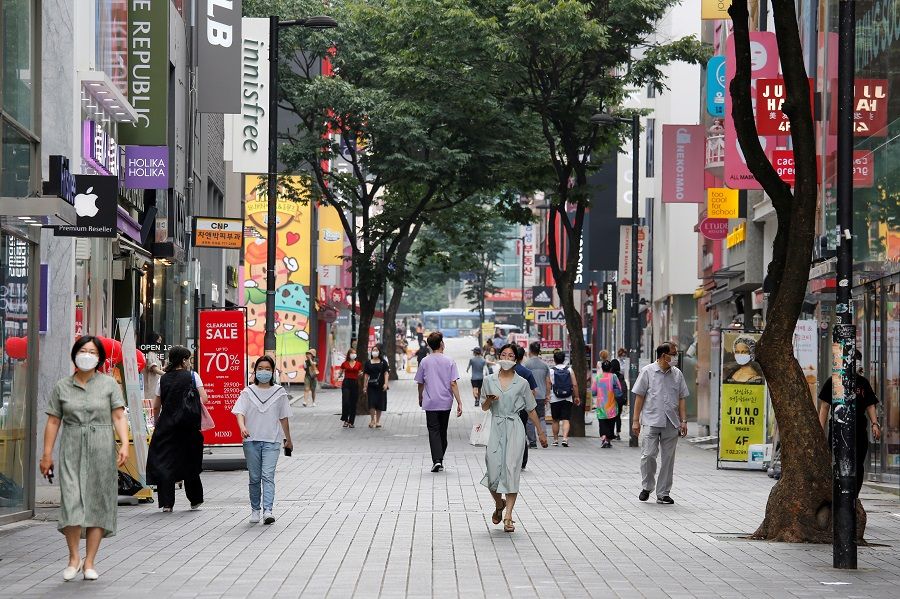 People wearing masks walk at Myeongdong shopping district, in Seoul, South Korea, 19 August 2020. (Heo Ran/Reuters)