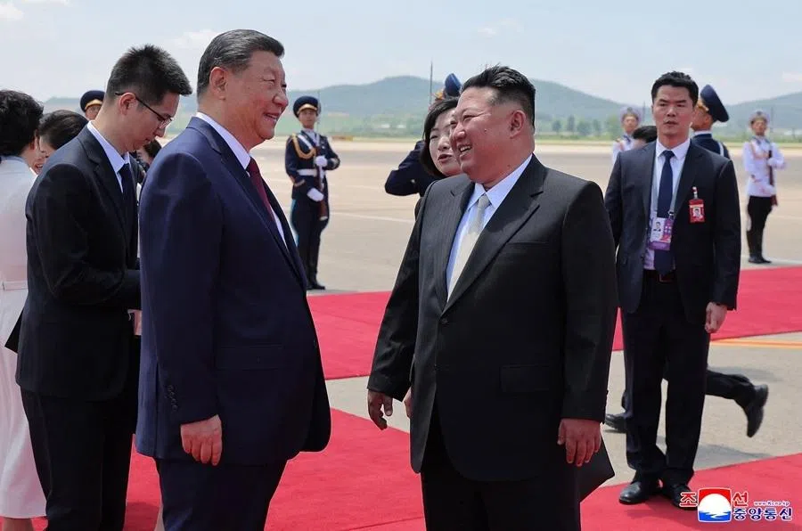 This picture taken on 8 June 2026 and released by North Korea's official Korean Central News Agency (KCNA) on 9 June 2026 shows North Korean leader Kim Jong Un (right) welcoming China's President Xi Jinping upon his arrival at Pyongyang Airport, North Korea.