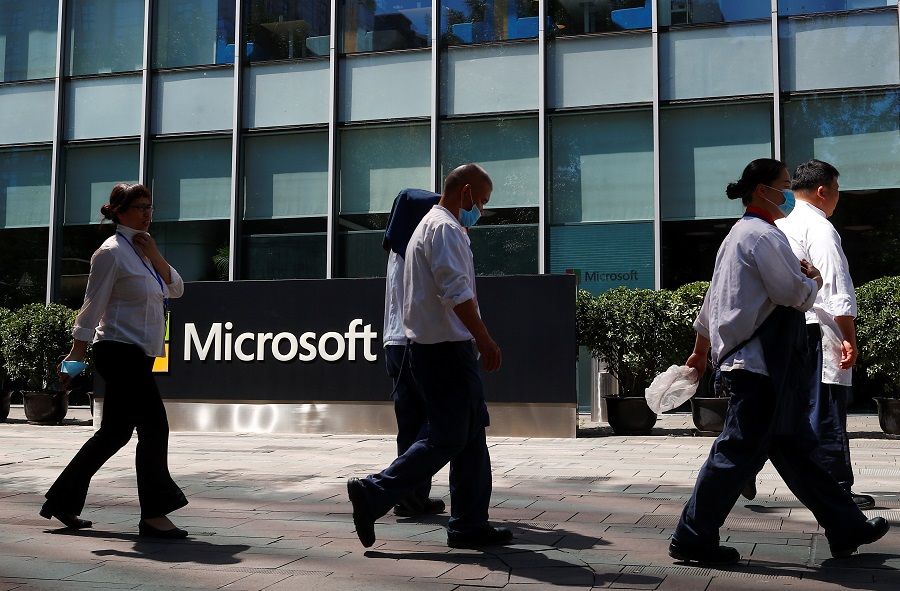 People walk past a Microsoft logo at the Microsoft office in Beijing, China, on 4 August 2020. (Thomas Peter/Reuters)