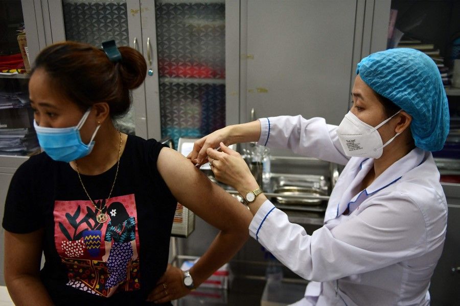 A woman receives the Moderna Covid-19 coronavirus vaccine at a primary school in Hanoi on 27 July 2021. (Nhac Nguyen/AFP)