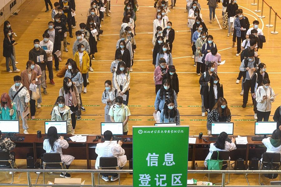 This photo taken on 27 April 2021 shows university students queueing to receive the China National Biotec Group (CNBG) Covid-19 coronavirus vaccine at a university in Wuhan, Hubei province, China. (STR/AFP)