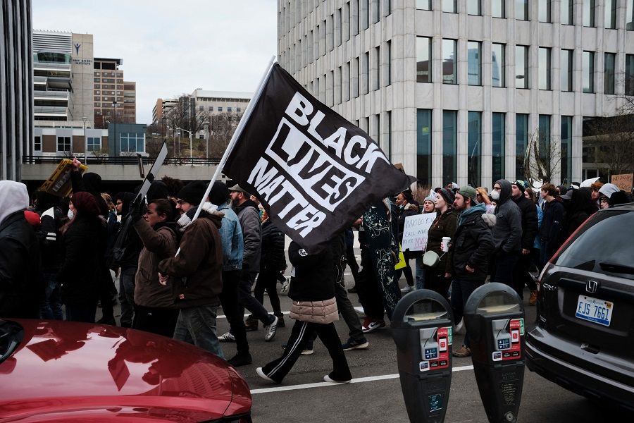 Protesters hold a Black Lives Matter flag as they march for Patrick Lyoya, a Black man who was fatally shot by a police officer, in downtown Grand Rapids, Michigan, US, 16 April 2022. (Mustafa Hussain/AFP)