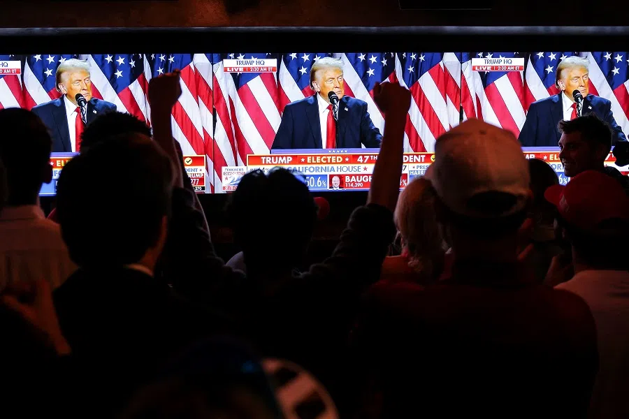 Supporters of Republican presidential nominee former US President Donald Trump react next to screens showing Trump speak from the Palm Beach County Convention Center, as they attend the New York Young Republican Club watch party during the 2024 US presidential election, in Manhattan, New York City, US, on 6 November 2024. (Andrew Kelly/Reuters)