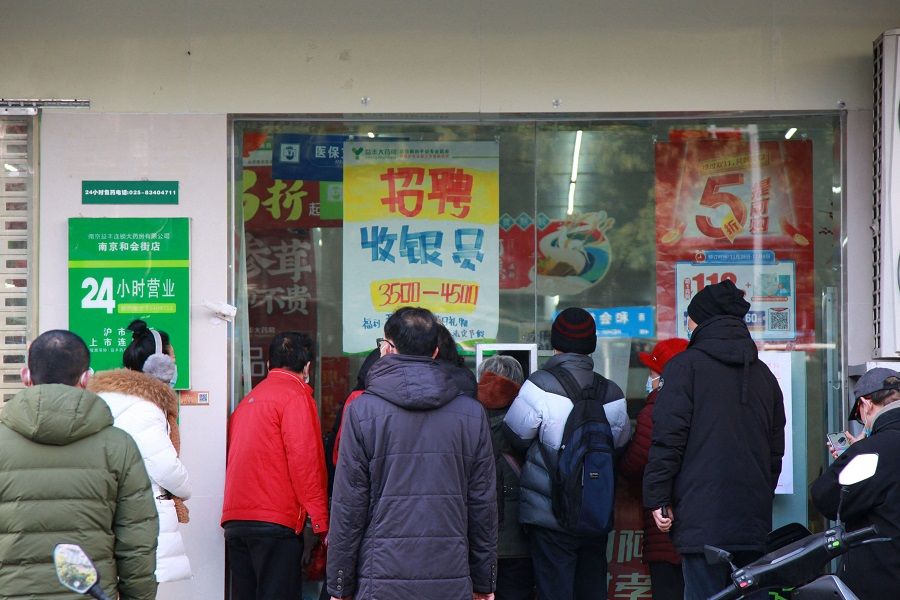 People queue to buy medicine at a pharmacy amid the Covid-19 pandemic in Nanjing, Jiangsu province, China, on 20 December 2022. (AFP)