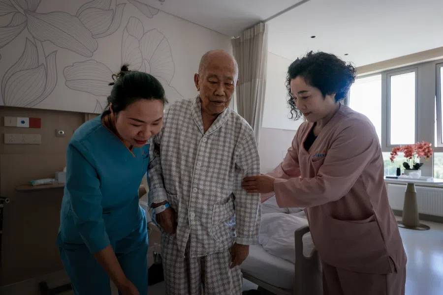 Staff members help a resident at the Perennial Rehabilitation Hospital in Tianjin on 3 June 2025. (SPH Media)