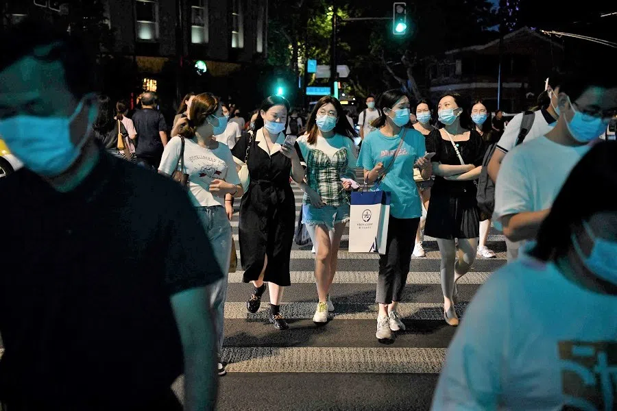 People cross a road during rush hour in Shanghai, China, on 3 September 2021. (Greg Baker/AFP)
