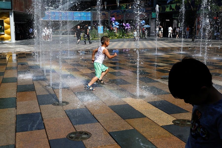 Children cool off in a water fountain amid a heatwave in Beijing, China, 22 June 2023. (Tingshu Wang/Reuters)