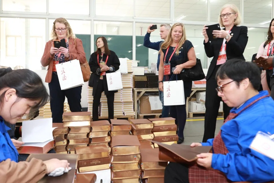 Visitors getting a look at the Bibles churned out by Amity Printing Co. in Jiangsu. (United Bible Societies)