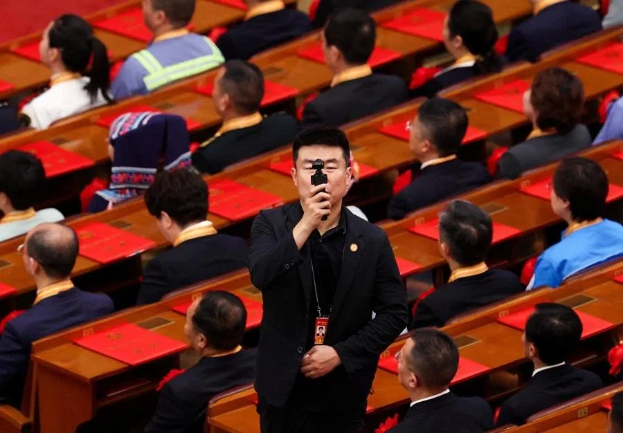 A man films using a mini camera during a ceremony marking the 105th anniversary of the founding of the Communist Party of China at the Great Hall of the People in Beijing, China, on 1 July 2026.