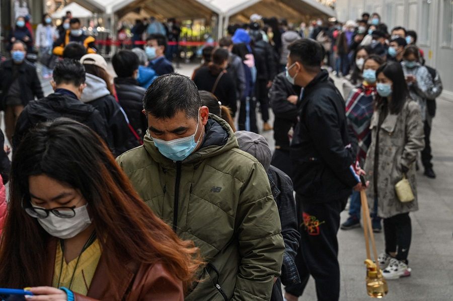 People queue to be tested for the Covid-19 coronavirus at Huashan Hospital in Shanghai, China, on 23 March 2022. (Hector Retamal/AFP)