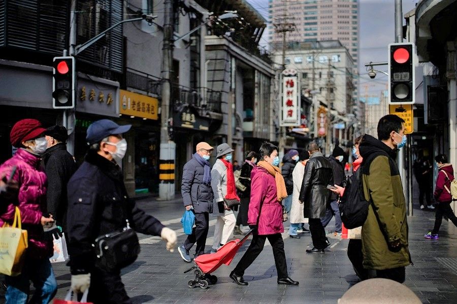 People wearing protective masks visit a main shopping area in Shanghai, China, 21 January 2022. (Aly Song/Reuters)