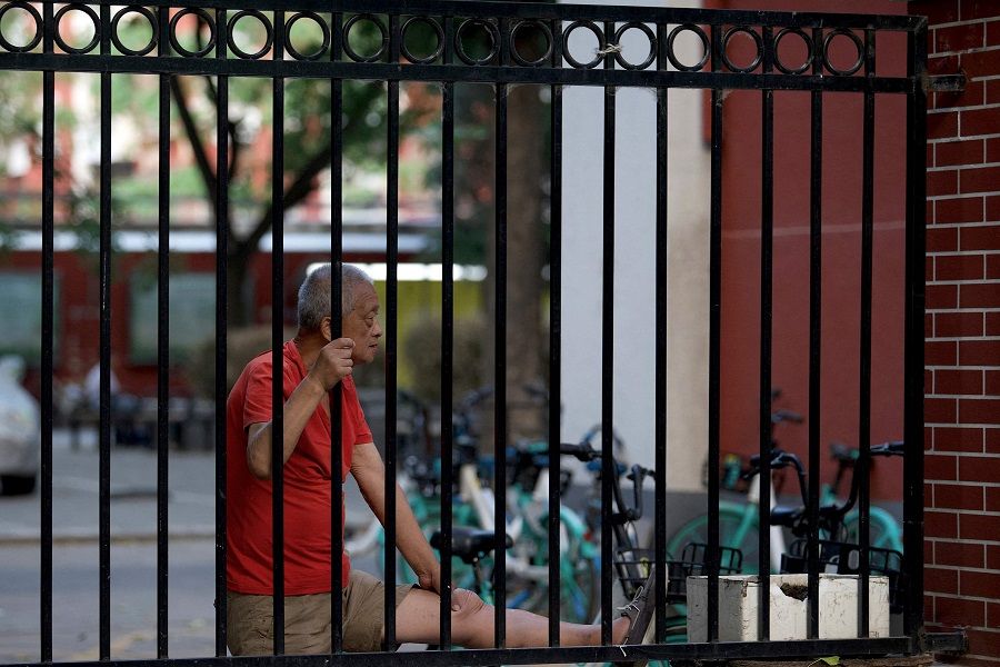 An elderly man exercises inside a residential area under lockdown due to Covid-19 restrictions in Beijing on 22 May 2022. (Noel Celis/AFP)