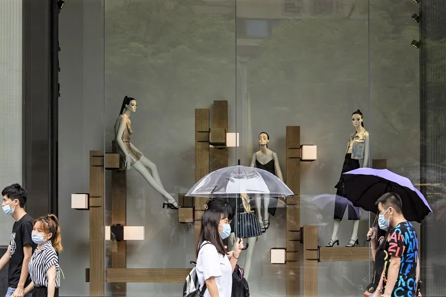 Pedestrians wearing protective masks walk down Nanjing East Road in Shanghai, China on 14 August 2021. (Qilai Shen/Bloomberg)