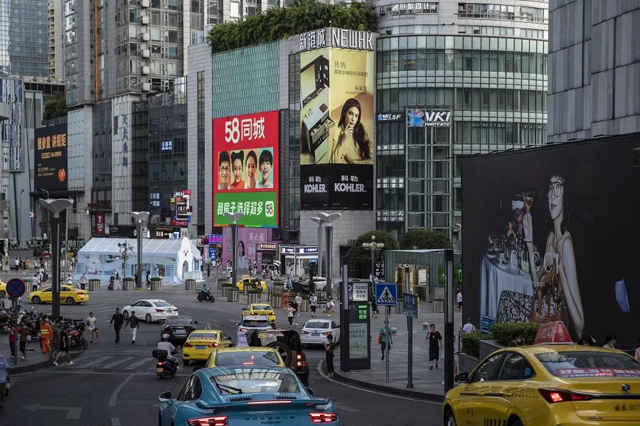 Vehicles travel along a road in a major shopping district in Chongqing, China, on 17 August 2022. (Bloomberg)