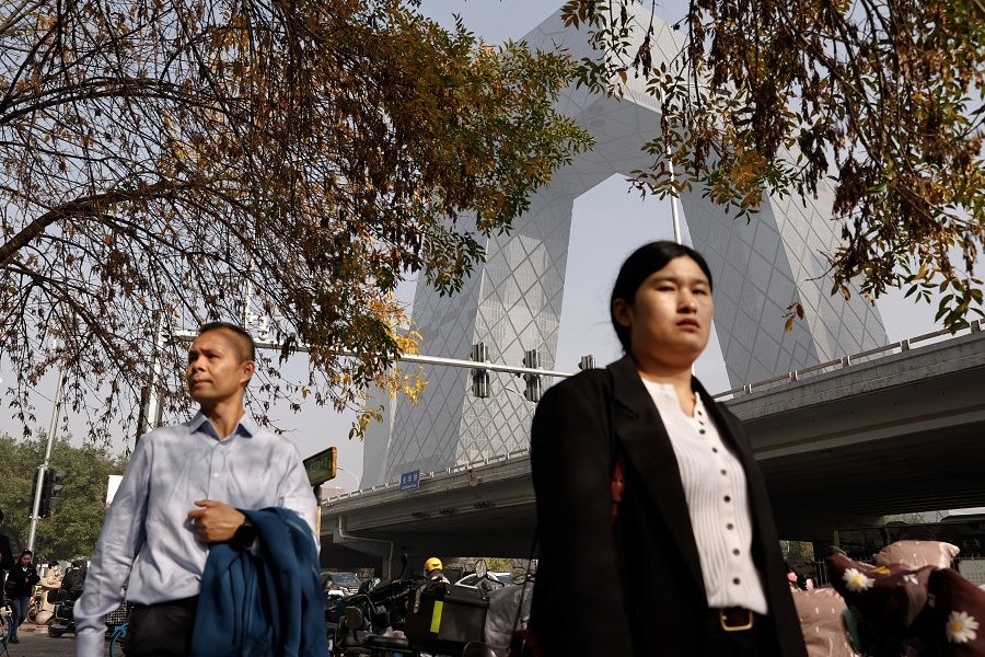 People walk in Beijing's central business district, in China, on 1 November 2023. (Tingshu Wang/Reuters)