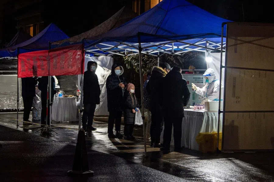 This photo taken on 25 December 2021 shows residents queueing to undergo nucleic acid tests for the Covid-19 coronavirus in Xi'an in China's northern Shaanxi province. (AFP)