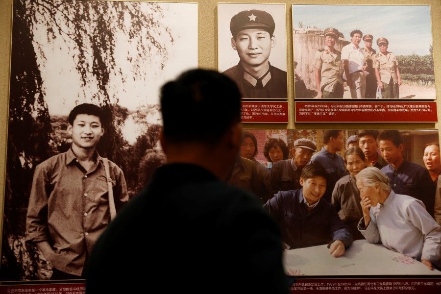 A man stands in front of images of Chinese President Xi Jinping displayed at the Museum of the Communist Party of China in Beijing, China, 11 November 2021. (Carlos Garcia Rawlins/Reuters)