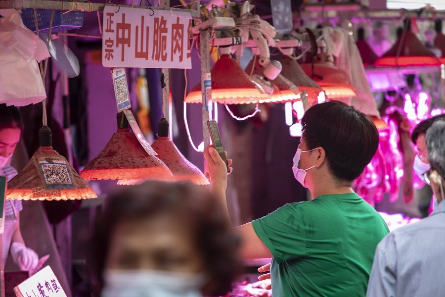 A customer uses a mobile phone to scan a QR code to make a digital payment at an open-air market in Guangzhou, China on 24 May 2021. (Qilai Shen/Bloomberg)