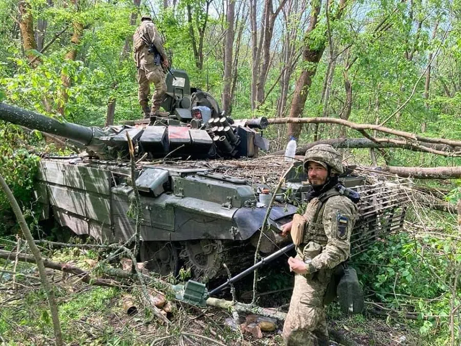 This handout picture of the Ukraine Ministry of Defence taken in an unknown place in Ukraine and released on 16 May 2022 shows Ukrainian servicemen examining a destroyed Russian tank, amid Russia's invasion of Ukraine. (Ministry of Defence of Ukraine/AFP)