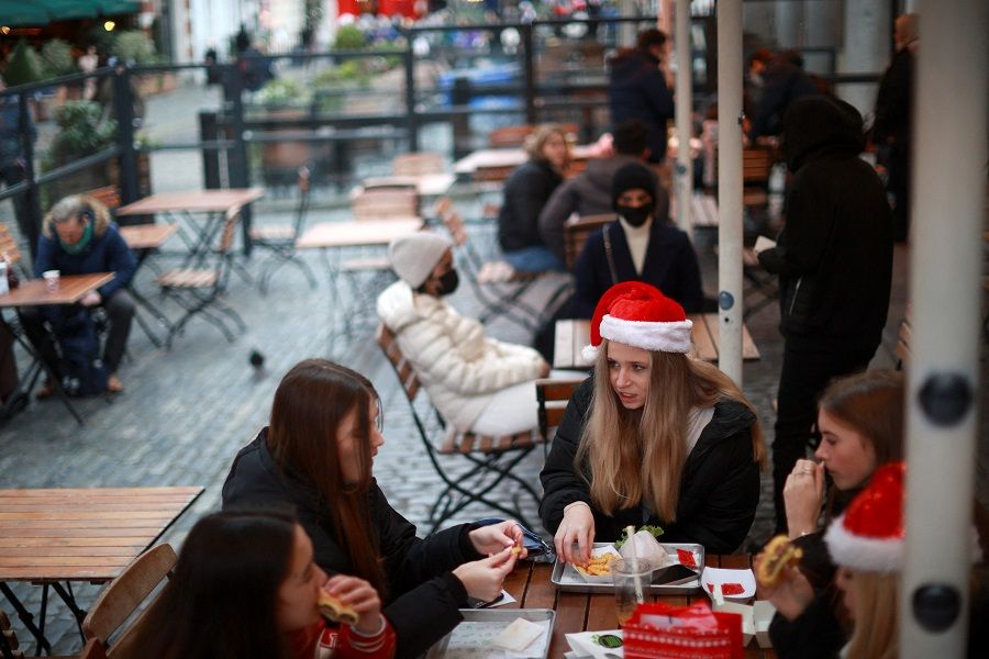 People dining al fresco in the Soho district of central London, 20 December 2021. (Hannah McKay/Reuters)