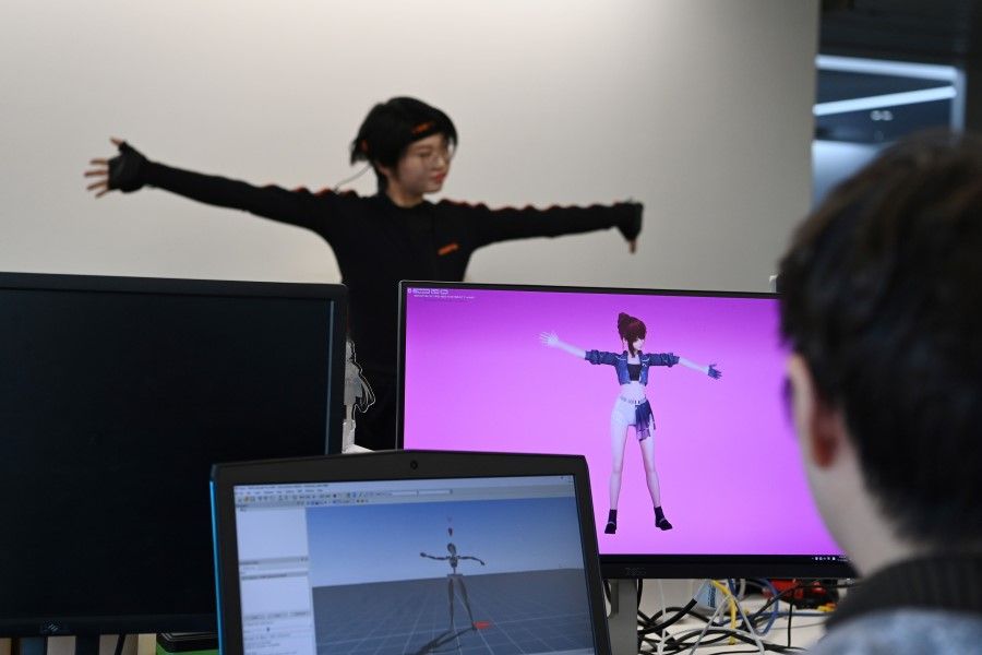 In this photo taken on 12 November 2020, a staff member demonstrates the use of animation software at the Beijing Mizhi Tech offices in Beijing. (Greg Baker/AFP)