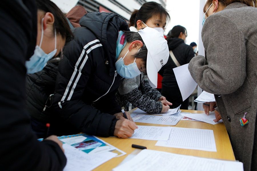 Jobseekers visit a booth at a job fair in Beijing, China, 16 February 2023. (Florence Lo/Reuters)
