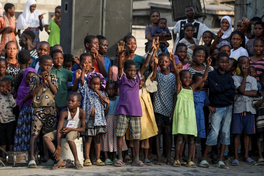 Children react as they watch a performance by local dancers during an annual slum party in Oworonshoki, Lagos, Nigeria, 23 December 2022. (Temilade Adelaja/Reuters)