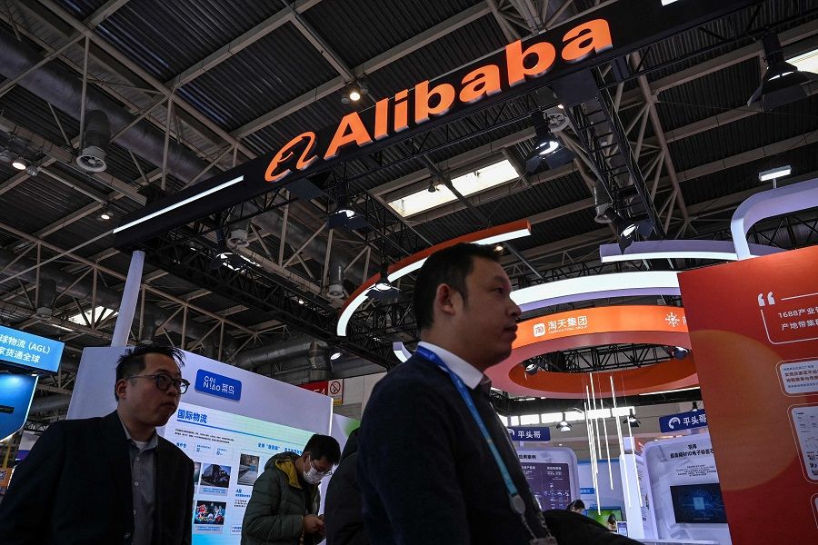 People walk past an Alibaba booth during the China International Supply Chain Expo (CISCE) in Beijing, China, on 1 December 2023. (Jade Gao/AFP)