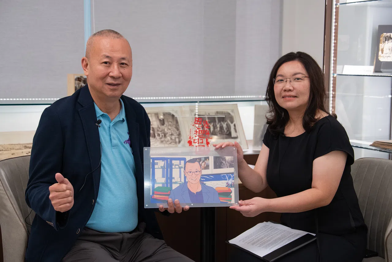 ThinkChina’s Charlene Chow presents Hsu Chung-mao with an illustrated portait at the latter’s studio in Taipei on 21 April 2026. (Photo: Yi Jina)