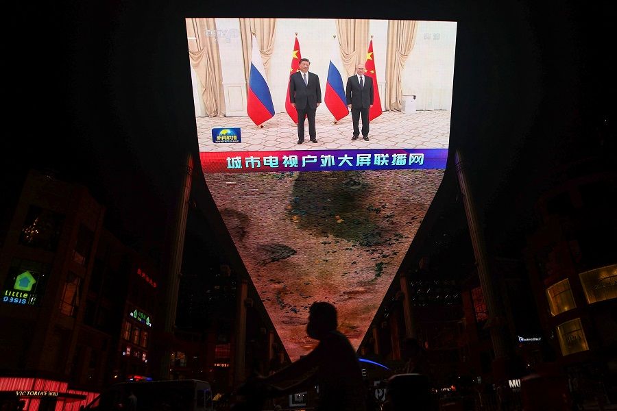 A giant screen broadcasts news footage of Chinese President Xi Jinping and Russian President Vladimir Putin posing for pictures during a meeting on the sidelines of the Shanghai Cooperation Organization (SCO) summit in Uzbekistan, in Beijing, China, 16 September 2022. (Tingshu Wang/Reuters)