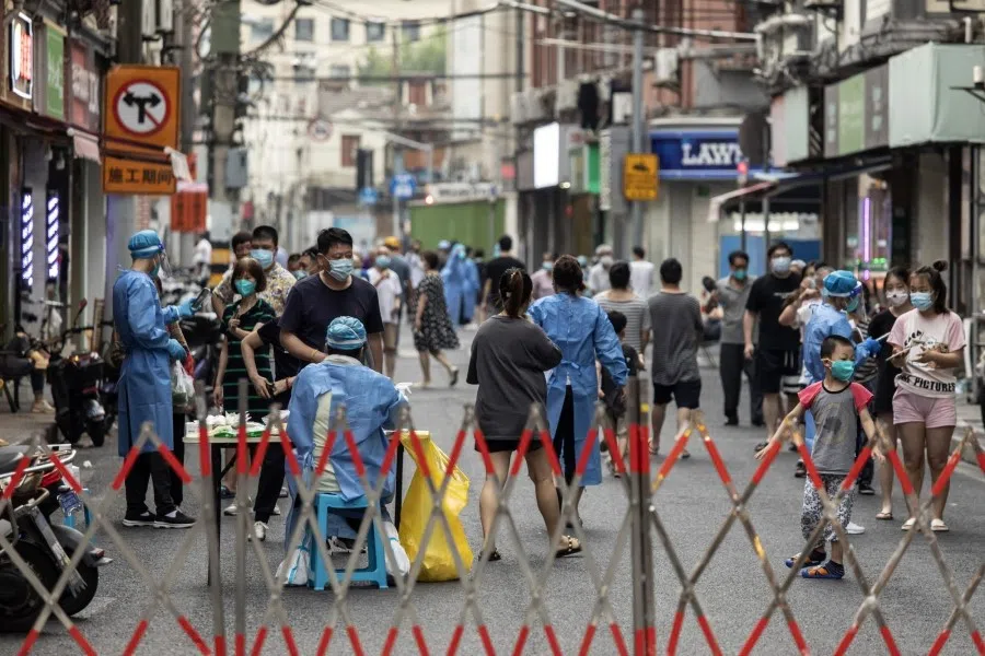 Healthcare workers in protective gear assist residents taking Covid-19 tests in Shanghai, China, on 19 July 2022. (Qilai Shen/Bloomberg)