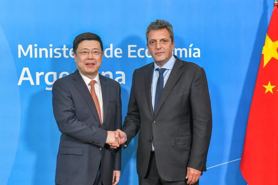 This handout photo released by the Argentine Economy Ministry shows Argentine Economy Minister Sergio Massa (right) and Chinese ambassador to Argentina Zou Xiaoli (left) shaking hands after signing an agreement to activate the swap between Argentina and China in Buenos Aires on 26 April 2023. (Handout/Argentina's Economy Ministry/AFP)