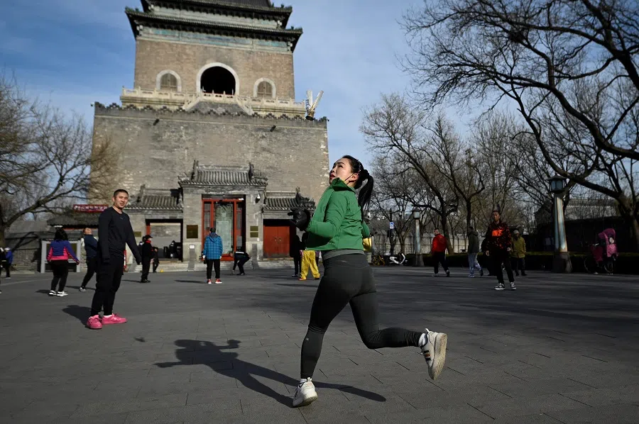 A woman kicks a shuttlecock at a square in Beijing on 10 January 2024. (Wang Zhao/AFP)