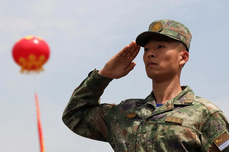A member of the Chinese People’s Liberation Army (PLA) Navy salutes at the entrance to the PLA Naval Submarine Academy, during a media tour to its open day ahead of the 75th founding anniversary of the Navy, in Qingdao, Shandong province, China, on 21 April 2024. (Florence Lo/Reuters)