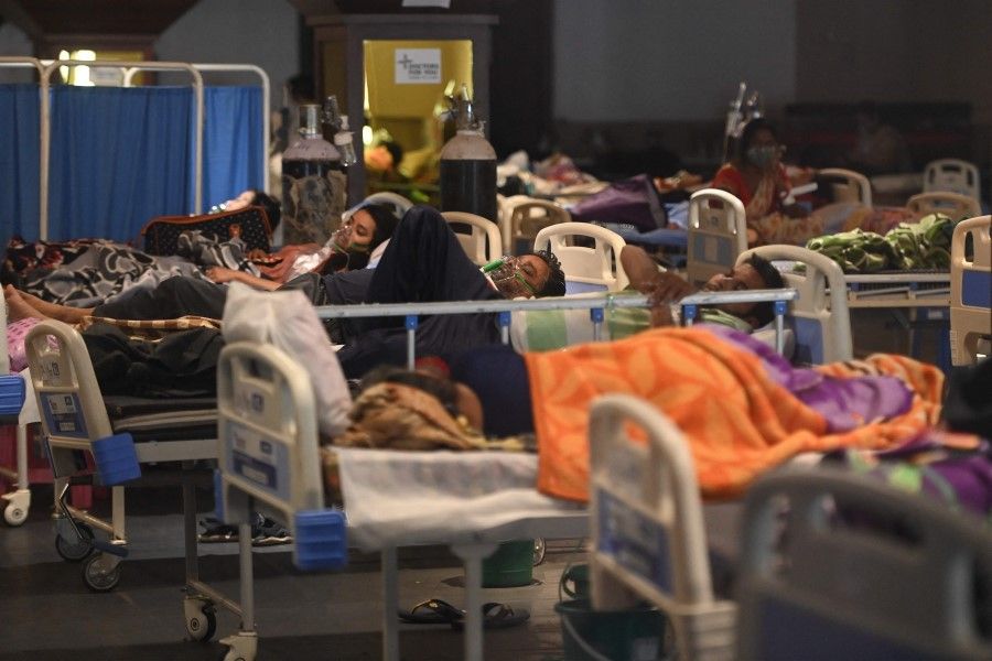 Patients breathe with the help of oxygen masks inside a banquet hall temporarily converted into a Covid-19 coronavirus ward in New Delhi on 27 April 2021. (Money Sharma/AFP)