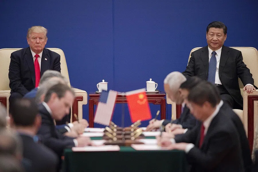 This file photo taken on 9 November 2017 shows US President Donald Trump (left) and Chinese President Xi Jinping attending a business leaders event inside the Great Hall of the People in Beijing. (Nicolas Asfouri/AFP)
