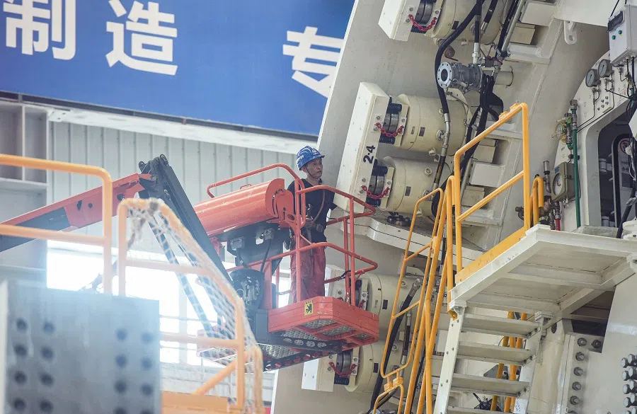 An employee works on a shield tunnelling machine at a factory in Hangzhou, Zhejiang province, China on 15 July 2021. (STR/AFP)