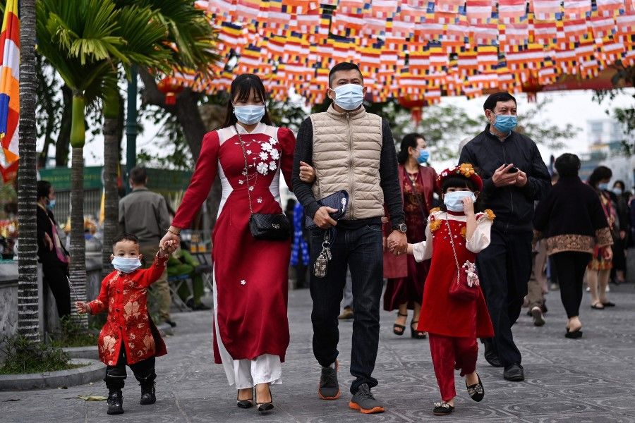 A Vietnamese family arrives to offer prayers at the Tran Quoc Pagoda, one of the oldest pagodas in Hanoi on 12 February 2021 on the first day of Lunar New Year or Tet celebrations. (Manan Vatsyayana/AFP)
