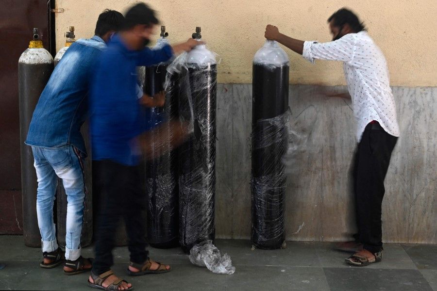 Staff unwrap oxygen cylinders at a newly set up Covid-19 coronavirus care centre in Mumbai on 26 April 2021. (Indranil Mukherjee/AFP)