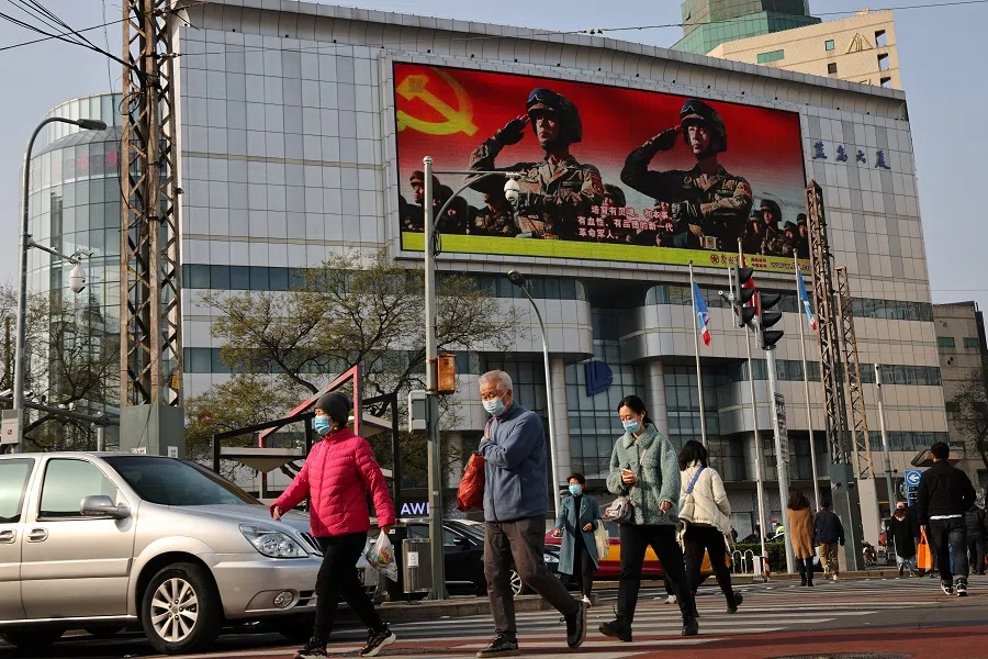 An advertisement of the People's Liberation Army overlooks a street scene in Beijing, China, 16 November 2021. (Thomas Peter/Reuters)