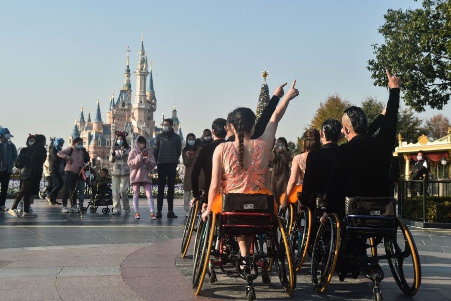 Wheelchair dancers from the Shanghai Oriental Pearl TV Tower Handicapped Art Troupe perform at Shanghai Disneyland on 3 December 2021, the International Day of Persons with Disabilities. (Jessica Yang/AFP)