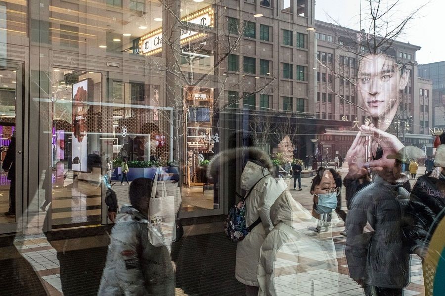 Pedestrians reflected in a store window in the Wangfujing shopping area in Beijing, China, on 10 February 2023. (Bloomberg)