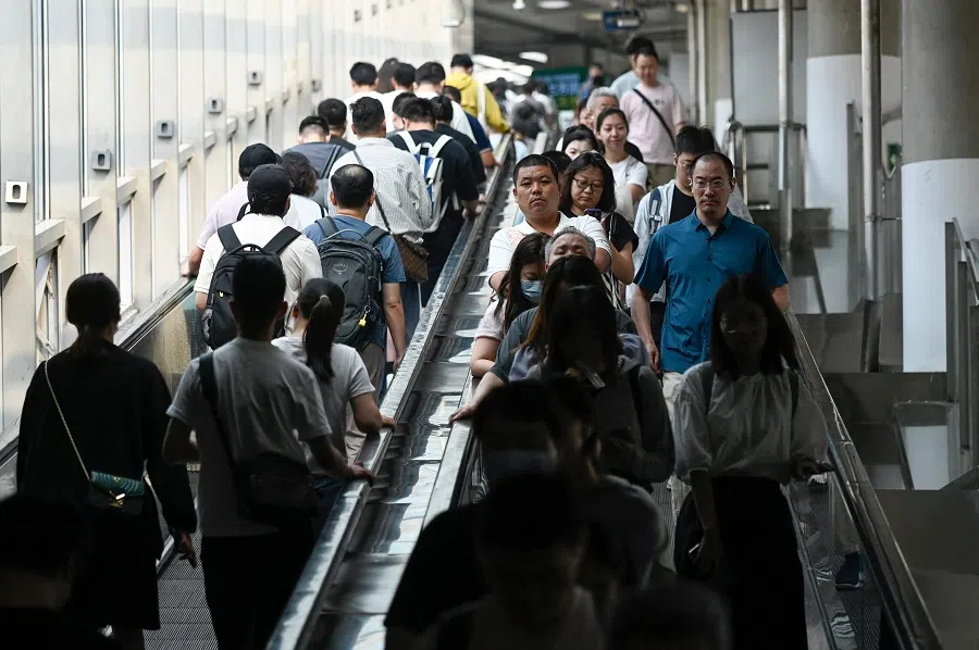 Commuters take the escalators at a subway station in Beijing, China on 10 July 2024.  (Wang Zhao/AFP)