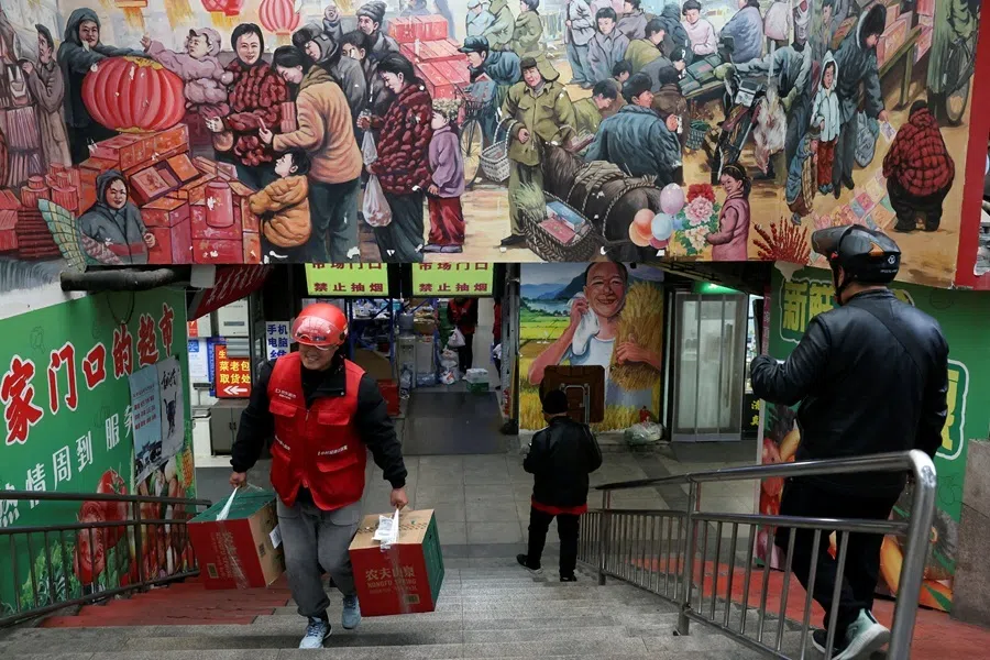 A JD.com delivery worker picks up grocery orders from a market in Beijing, China, on 17 October 2024.