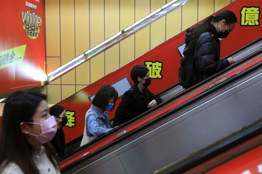 People wearing masks to prevent the spread of the coronavirus disease (Covid-19) ride on an escalator during morning rush hour at a subway station in Taipei, Taiwan, 30 November 2021. (I-Hwa Cheng/Reuters)