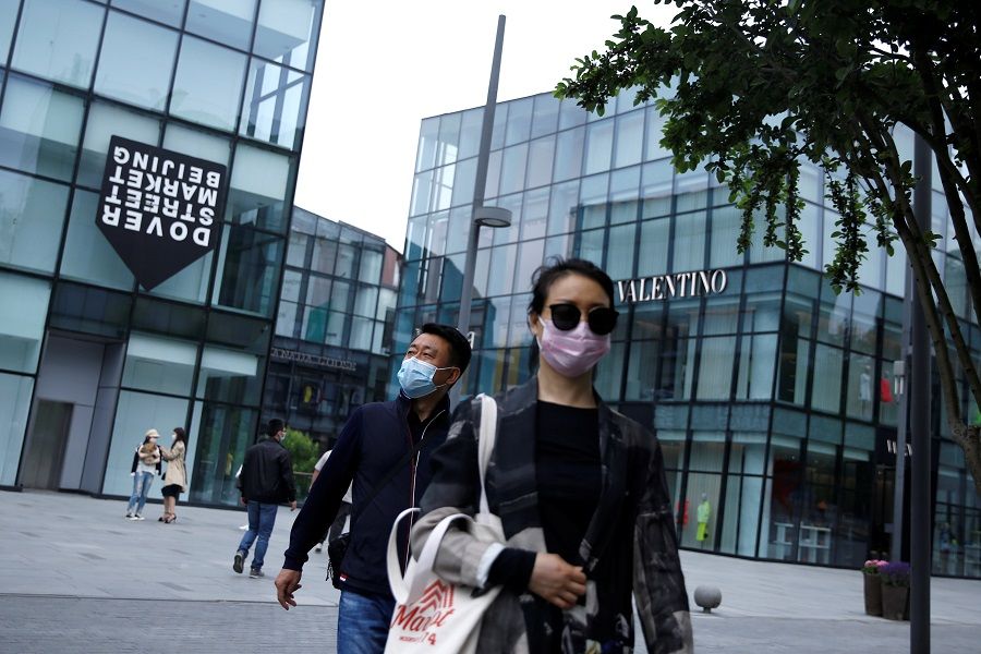 People wearing face masks shop at the Sanlitun shopping area in Beijing, China, on 4 May 2020. (Tingshu Wang/Reuters)
